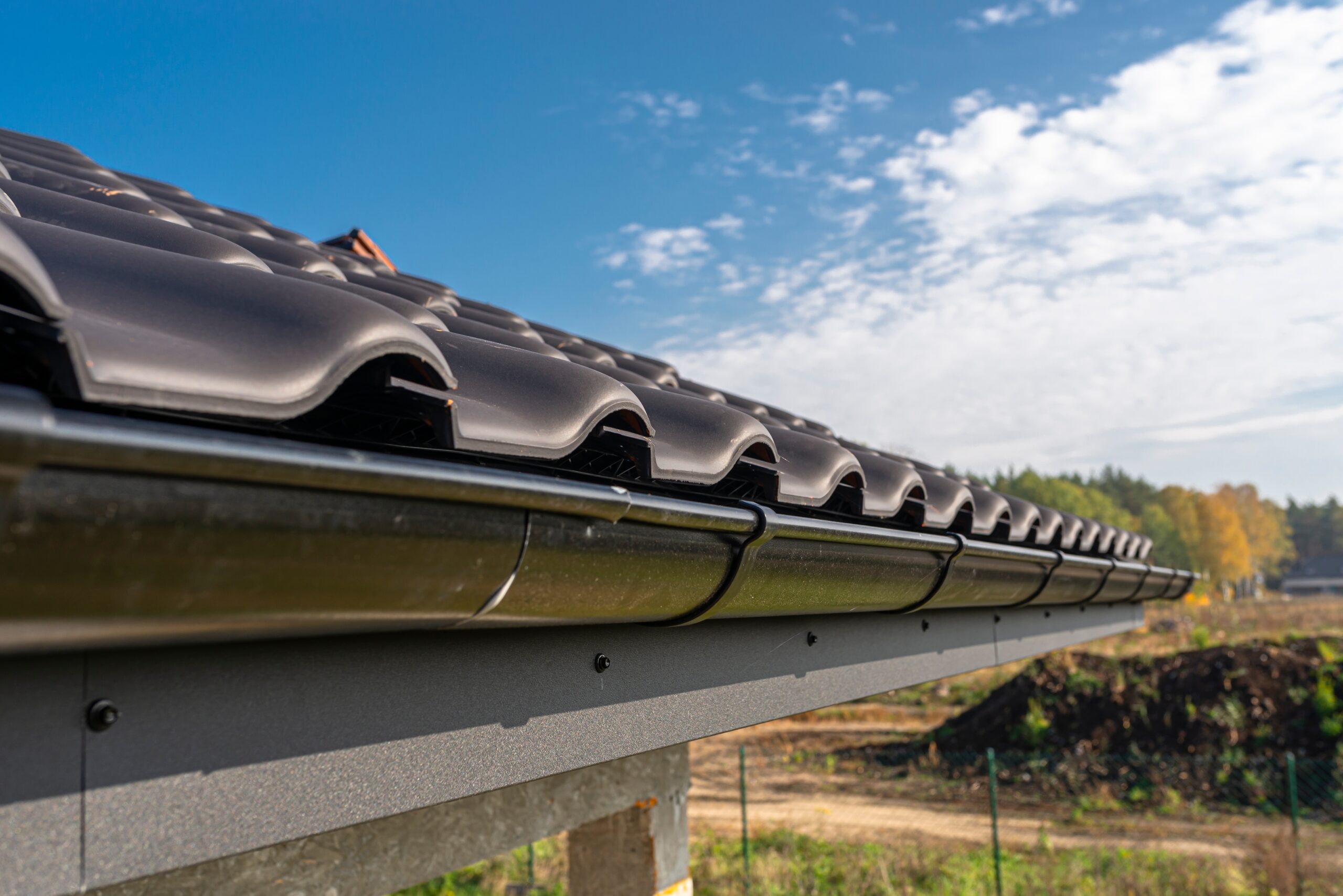 a-metal-black-gutter-on-a-roof-covered-with-ceram-2023-11-27-05-16-19-utc