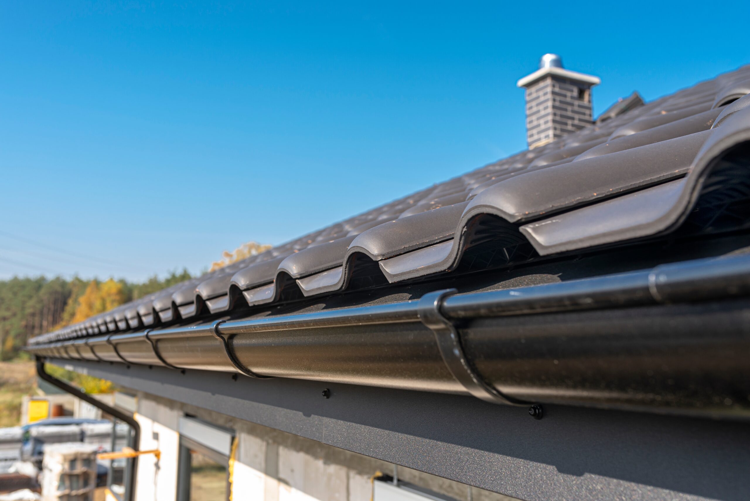 a-metal-black-gutter-on-a-roof-covered-with-ceram-2026-03-24-09-02-20-utc